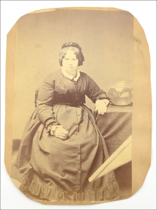 Item #22587 Trimmed mounted studio photograph portrait of a seated woman, with a visible light...